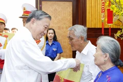 El secretario general del Partido Comunista de Vietnam, To Lam, entrega obsequios a familias beneficiarias de políticas sociales y a personas con méritos revolucionarios. (Foto: VNA)