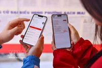 Electores revisan informaciones de candidatos a los comicios parlamentarios en la aplicación VNeID. (Foto: VNA)