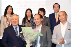 El viceprimer ministro permanente vietnamita, Nguyen Hoa Binh, entrega flores al presidente de ViLaB, Phung Quoc Tri. (Fuente: VNA)