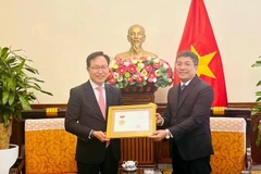 El viceministro permanente de Relaciones Exteriores Nguyen Minh Vu entregó la medalla conmemorativa “Por la causa de la diplomacia vietnamita” al director general del grupo surcoreano Samsung en el país indochino, Choi Joo Ho. (Fuente: VNA)