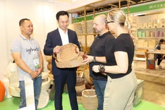 Clientes internacionales aprenden sobre los productos artesanales vietnamitas. (Fuente: VNA)