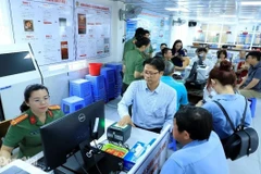 Funcionarios del Departamento de Inmigración guían con entusiasmo y atención a los extranjeros en el proceso de otorgamiento de cuentas de identificación electrónica de nivel 2. (Foto: sggp.org.vn)