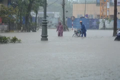 Las intensas lluvias prolongadas y las profundas inundaciones dificultan la circulación de vehículos. (Foto: VNA)