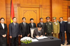 El secretario general del Partido Popular Revolucionario de Laos y presidente del país, Thongloun Sisoulith, escribe en el libro de condolencias. (Fuente: VNA)