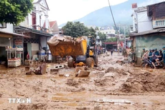 Se movilizaron excavadoras para nivelar y recoger el lodo, las ramas de árboles y la basura arrastrada por la reciente inundación en la comuna de Song Ma, provincia de Son La. (Foto: VNA)
