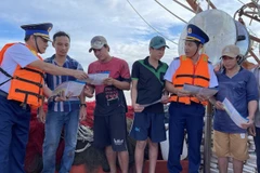Las fuerzas encargadas de hacer cumplir la ley marítima difunden información sobre la pesca IUU entre los pescadores. (Foto: VNA)