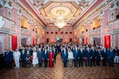 Delegados e invitados realizan la ceremonia de izamiento de la bandera en el evento. (Foto: VNA)
