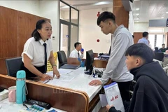 Funcionarios del Centro de Administración Pública del Distrito de Tam Ky, en la ciudad de Da Nang, guían a los ciudadanos en los trámites. (Foto: VNA)