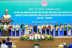 El primer ministro Pham Minh Chinh entrega flores para felicitar a los jóvenes vietnamitas destacados. (Fuente: VNA)