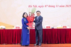 El miembro del Buró Político y permanente del Secretariado del Comité Central del Partido Comunista de Vietnam (PCV), Tran Cam Tu, entregó flores para felicitar a Bui Thi Minh Hoai, nueva presidenta del Frente de la Patria. (Fuente: VNA)