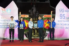 Ngo Minh Hai, secretario de la Unión de Jóvenes de Ciudad Ho Chi Minh y presidente de la Unión de Jóvenes de Vietnam en Ciudad Ho Chi Minh, entrega retratos a la familia de la Heroica Madre Vietnamita Nguyen Thi Dau y sus dos hijos, los mártires Tran Thi Sau y Tran Van Chan. (Foto: VNA)