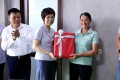 La directora general de la VNA, Vu Viet Trang, entrega obsequio a una familia que recibió apoyo de la agencia para construir una nueva casa. (Foto: VNA)