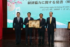 El secretario del Comité del Partido de Vinh Long, Tran Van Lau, entrega un obsequio conmemorativo a Tokihiro Nakamura, gobernador de la prefectura de Ehime, Japón. (Foto: VNA)