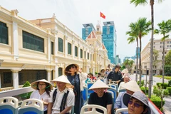Turistas visitan la sede del Comité Popular - Consejo Popular de Ciudad Ho Chi Minh en un autobús de dos pisos. (Fuente: VNA)
