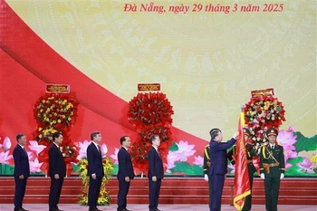 El secretario general del Partido Comunista de Vietnam, To Lam, coloca la Orden de Trabajo de primera clase en la bandera tradicional de la ciudad de Da Nang. (Foto: VNA)