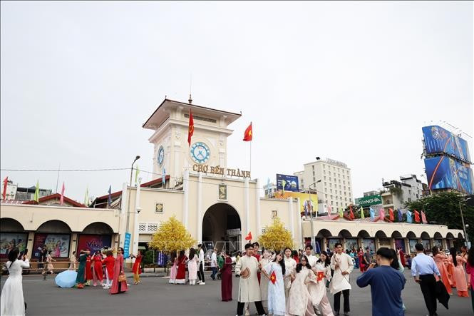 Turistas posan para fotos frente al mercado Ben Thanh, en Ciudad Ho Chi Minh. (Foto: VNA)