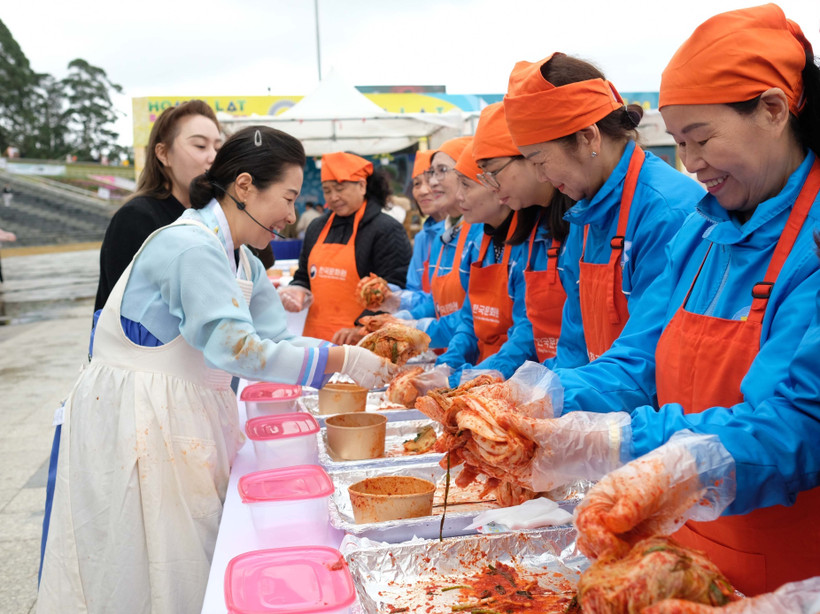 Bajo la guía de la instructora culinaria surcoreana Kim Eun Ja, lugareños y turistas preparan con entusiasmo kimchi con ingredientes de Da Lat. (Foto: VNA)