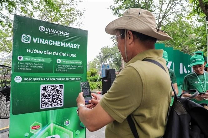 Un hombre escanea el código QR de la plataforma de comercio electrónico VinachemMart (Foto: VNA)