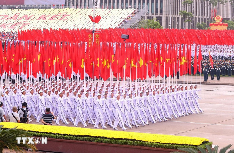 La formación con la bandera del Partido y la bandera nacional (Foto: VNA)