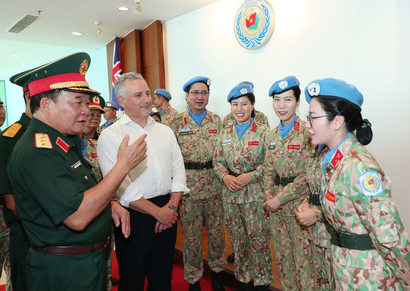 El viceministro vietnamita de Defensa, coronel general Hoang Xuan Chien, y el subsecretario de Defensa de Australia, Hugh Jeffrey, intercambian con las mujeres oficiales (Foto: VNA)