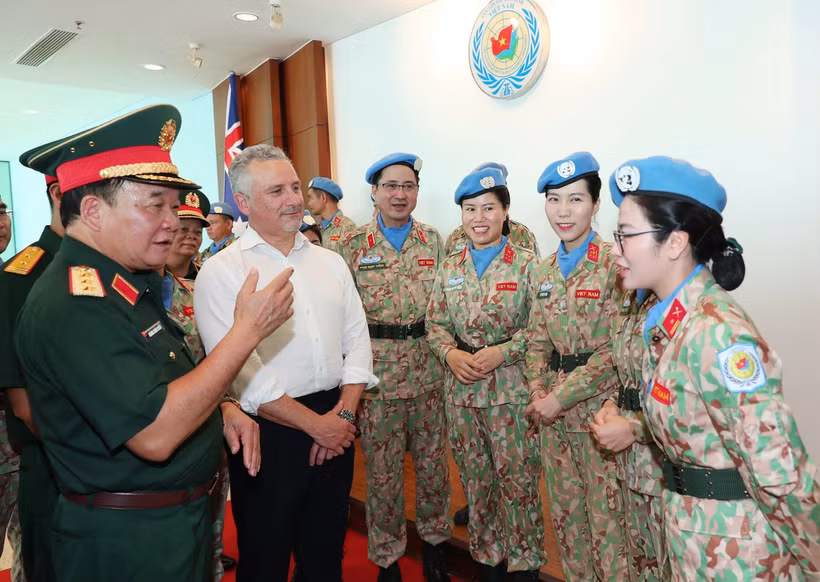 El viceministro vietnamita de Defensa, coronel general Hoang Xuan Chien, y el subsecretario de Defensa de Australia, Hugh Jeffrey, intercambian con las mujeres oficiales (Foto: VNA)