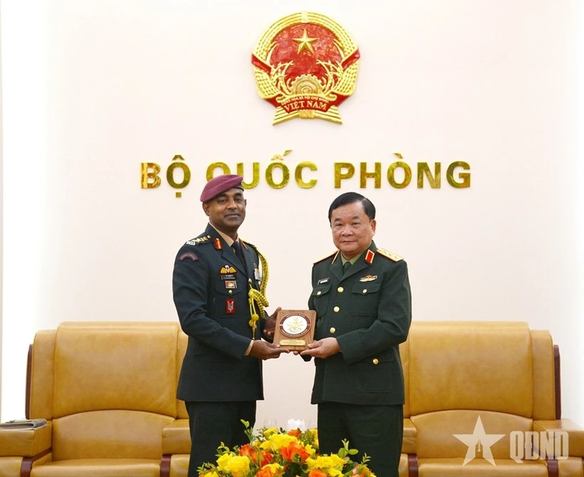 El viceministro de Defensa vietnamita, teniente general Hoang Xuan Chien (derecha), recibe un obsequio del coronel S. Muthukrishnan, agregado de Defensa de la India en Hanoi (Foto: qdnd.vn)