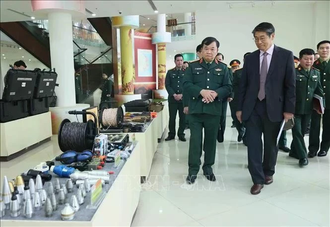 El coronel general Hoang Xuan Chien (izquierda), viceministro de Defensa de Vietnam, y el embajador de Japón en Hanoi, Ito Naoki, aprecian los modelos de procesamiento de señales de material explosivo en el VNMAC. (Foto: VNA)