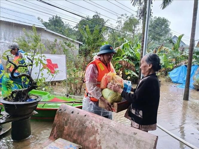 Funcionarios y voluntarios de la Cruz Roja brindan ayuda a las personas afectadas por las inundaciones en la ciudad de Hue. (Foto: VNA)