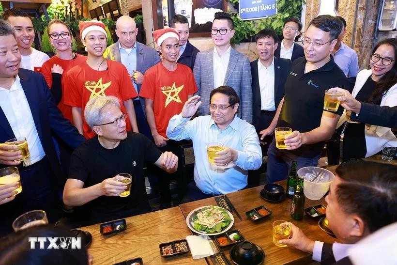 El primer ministro de Vietnam, Pham Minh Chinh, y el director ejecutivo de NVIDIA, Jensen Huang, disfrutan de la comida callejera de Hanoi el 5 de diciembre de 2024. (Foto: VNA)