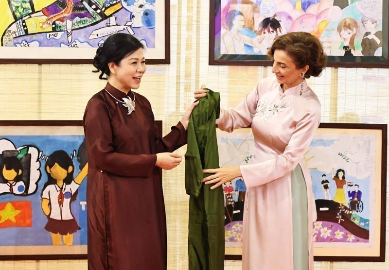 Ngo Phuong Ly (izq.), esposa del secretario general del Partido Comunista de Vietnam, To Lam, presenta un Ao Dai (túnica tradicional vietnamita) a la directora general de la UNESCO, Audrey Azoulay. (Foto: tuoitre.vn)