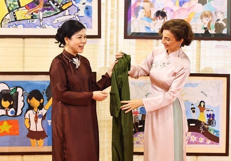 Ngo Phuong Ly (izq.), esposa del secretario general del Partido Comunista de Vietnam, To Lam, presenta un Ao Dai (túnica tradicional vietnamita) a la directora general de la UNESCO, Audrey Azoulay. (Foto: tuoitre.vn)