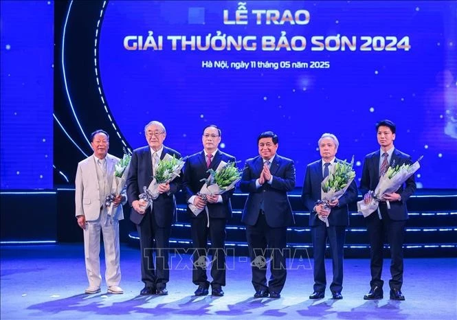 El viceprimer ministro Nguyen Chi Dung entrega flores para felicitar a los ganadores. (Foto: VNA)
