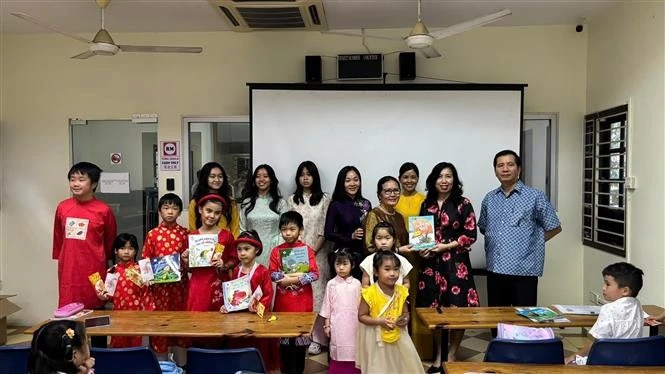 La viceministra de Relaciones Exteriores Le Thi Thu Hang (segunda desde la derecha) entrega libros a profesores y alumnos de una clase de lengua vietnamita en Malasia. (Foto: VNA)