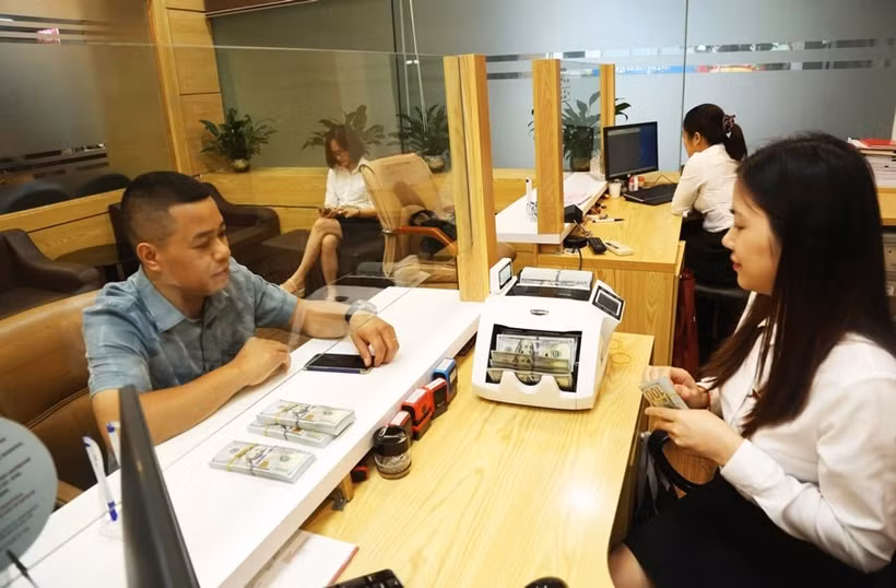Clientes realizan transacciones en el banco Agribank (Foto: https://hanoimoi.vn/)