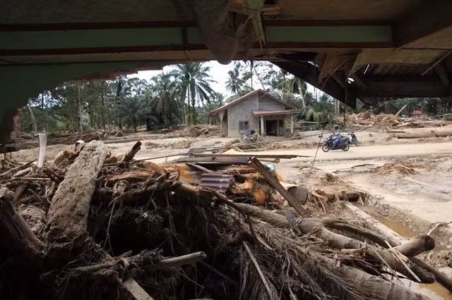 Un motociclista pasa por una zona de viviendas afectada por las inundaciones en el sur de Tapanuli, en el norte de Sumatra, el 1 de diciembre de 2025. (Foto: Antara)