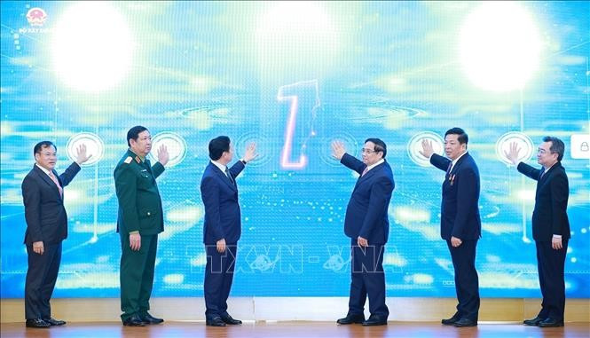 El primer ministro Pham Minh Chinh (tercero desde la derecha) y funcionarios presentan los nuevos sistemas de tecnología de la información del Ministerio de Construcción en la conferencia. (Foto: VNA)