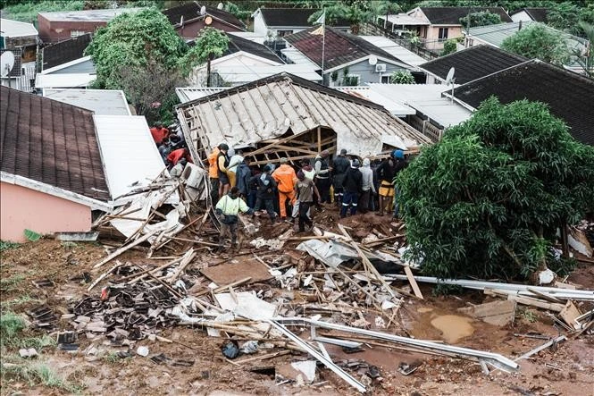 Búsqueda de víctimas atrapadas bajo una casa derrumbada tras las inundaciones en la ciudad de Durban, provincia de KwaZulu-Natal, Sudáfrica, el 12 de abril de 2022. (Foto: AFP/VNA)