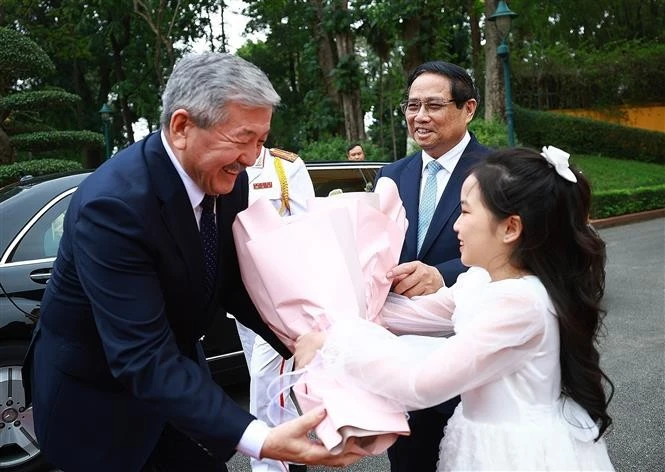 El primer ministro de Kirguistán, Adylbek Kasimalyev, recibe flores en la ceremonia de bienvenida. (Foto: VNA)