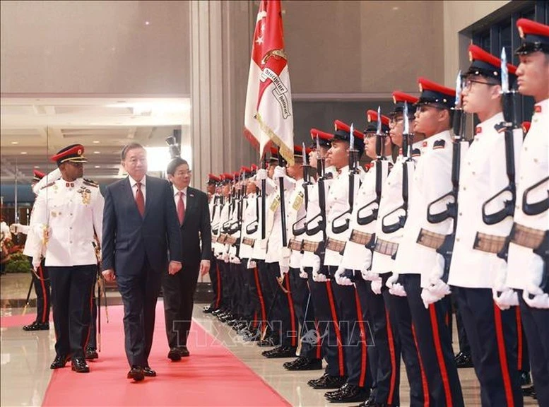 El secretario general del Partido Comunista de Vietnam, To Lam, y el primer ministro de Singapur, Lawrence Wong, pasan revista a la guardia de honor, con motivo de la visita del líder vietnamita a la nación insular (Foto. VNA)