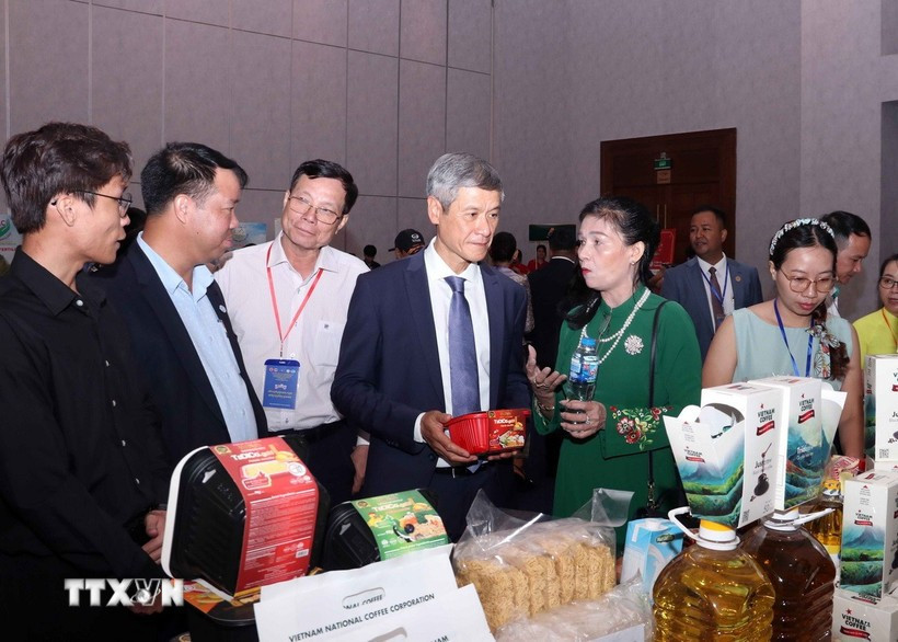 El embajador de Hanoi en Phnom Penh, Nguyen Minh Vu, y empresarios camboyanos visitan el stand vietnamita. (Foto: VNA)