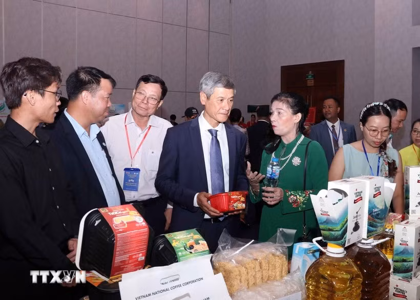 El embajador de Hanoi en Phnom Penh, Nguyen Minh Vu, y empresarios camboyanos visitan el stand vietnamita. (Foto: VNA)