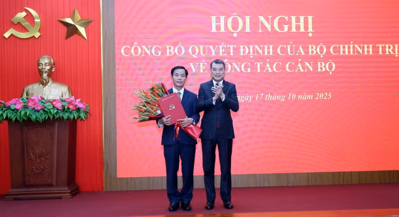 El miembro del Buró Político, secretario del Comité Central del PCV y jefe de su Comisión de Organización, Le Minh Hung (derecha), entrega la decisión a Nguyen Van Phuong (Foto: VNA)