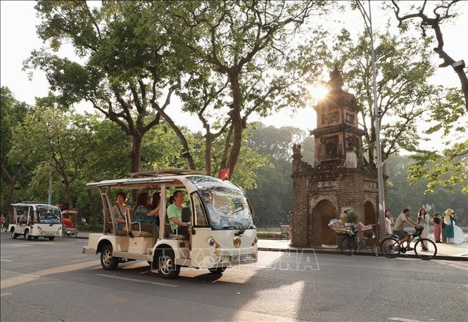 Turistas recorren el lago Hoan Kiem en coches eléctricos. (Foto: VNA)