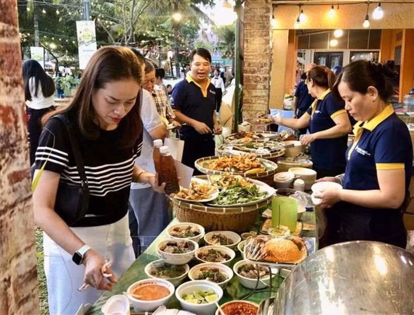 Los visitantes degustan los platos en el festival (Foto: VNA)