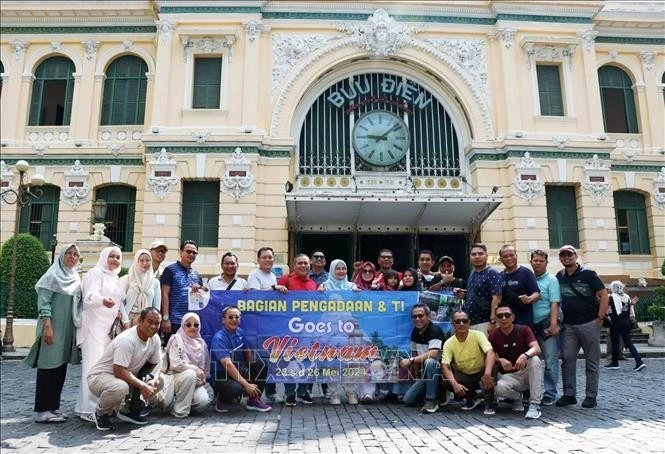 Los turistas extranjeros toman fotos en la Oficina Central de Correos, una de las atracciones más emblemáticas de Ciudad Ho Chi Minh. (Foto: VNA)