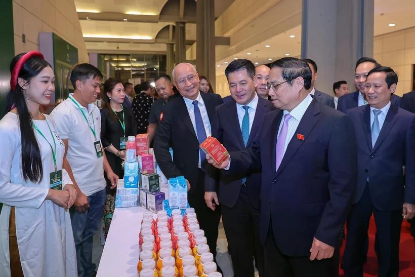 El primer ministro de Vietnam, Pham Minh Chinh, visita el stand del grupo TH al margen de la ceremonia de anuncio de productos que reciben reconocimiento de Marca Nacional. (Foto: Vietnam+)