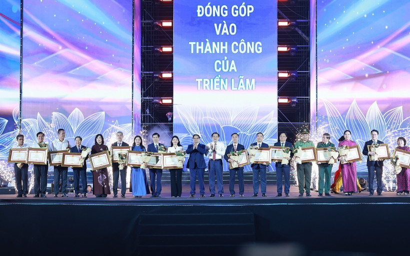 El primer ministro de Vietnam, Pham Minh Chinh, otorga certificados de mérito a colectivos e individuos con logros destacados en la organización de la exposición (Foto: VNA)