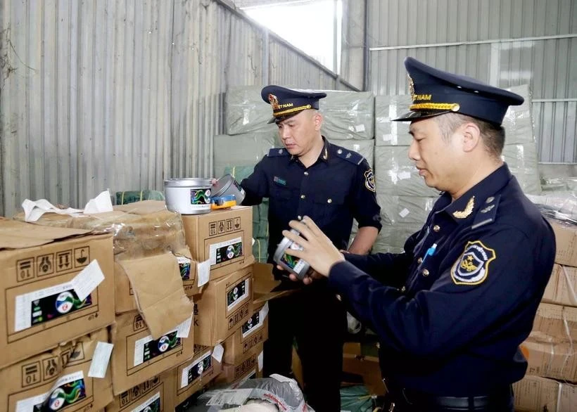 Agentes de aduanas del puesto fronterizo internacional de Huu Nghi (provincia de Lang Son) revisan las etiquetas de las mercancías importadas (Foto: VNA)