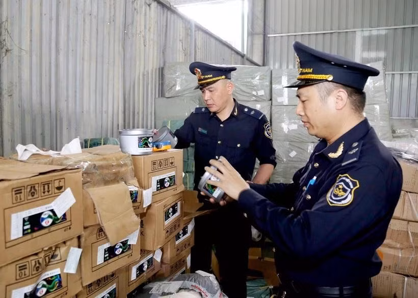 Agentes de aduanas del puesto fronterizo internacional de Huu Nghi (provincia de Lang Son) revisan las etiquetas de las mercancías importadas (Foto: VNA)