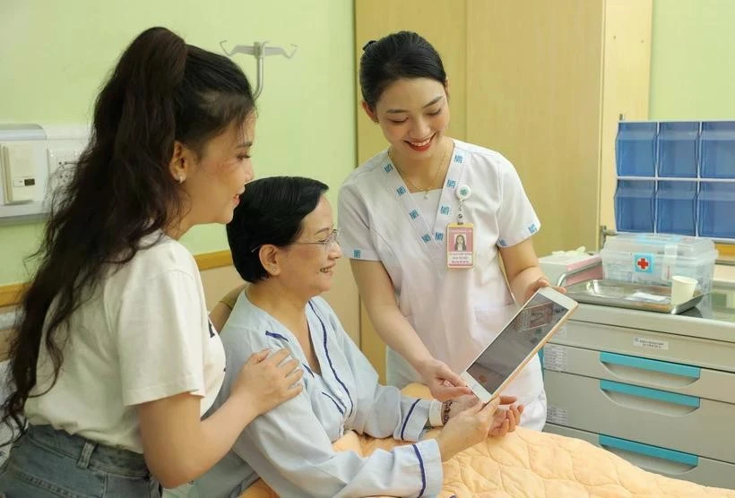 El personal médico utiliza una tableta para actualizar y compartir información con los pacientes. (Foto: VNA)